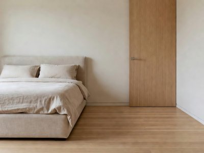 Balanced bedroom corner showing 26 inches of clear oak floor between a linen bed frame and a closet door